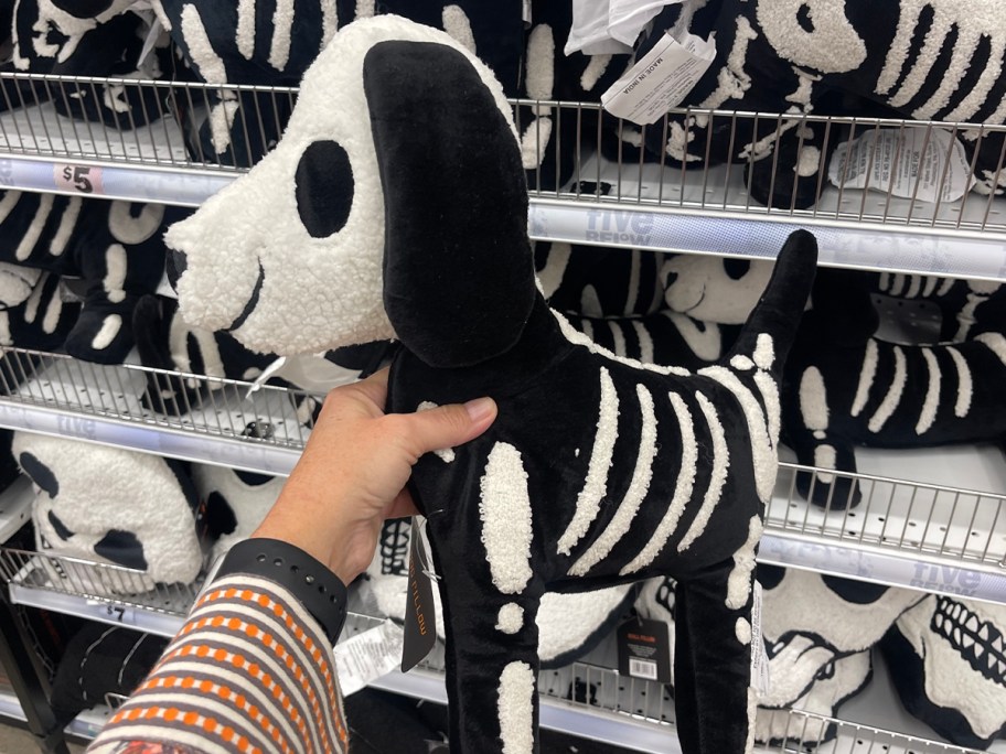 hand holding skeleton dog pillow 