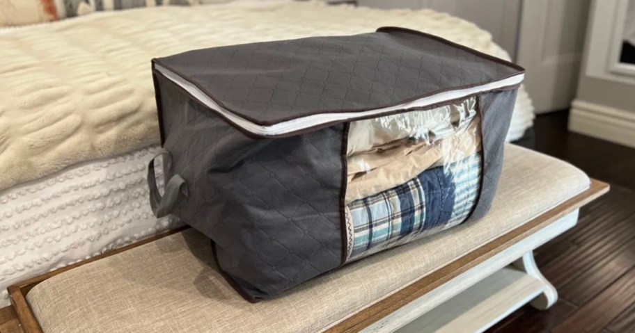 gray storage bag with blankets inside in room