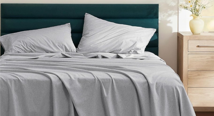 gray bedsheets displayed on top of a bed 