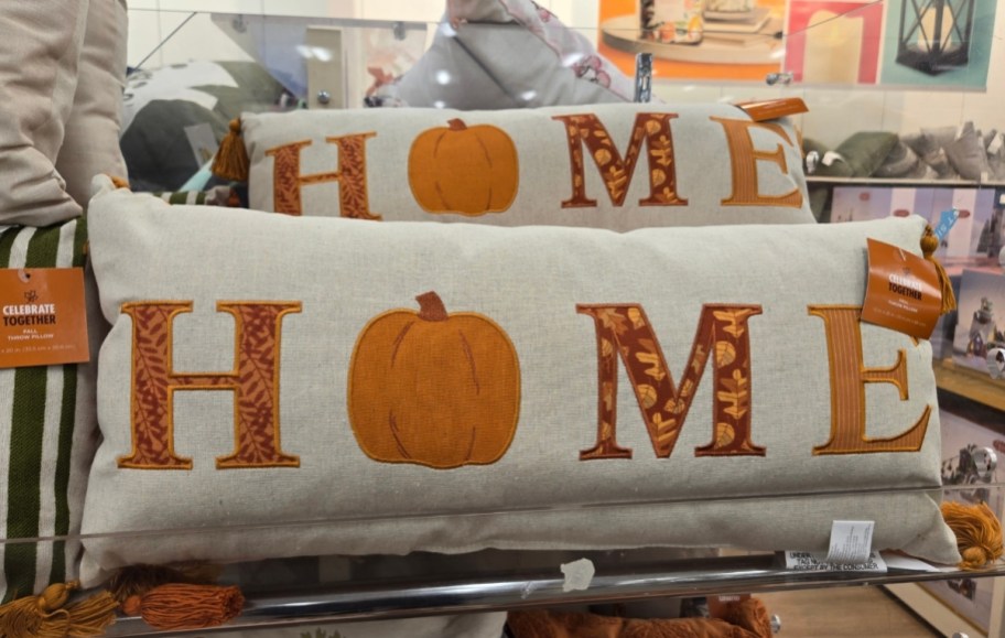 a lumbar throw pillow with the word home on the front in a fall inspired graphic