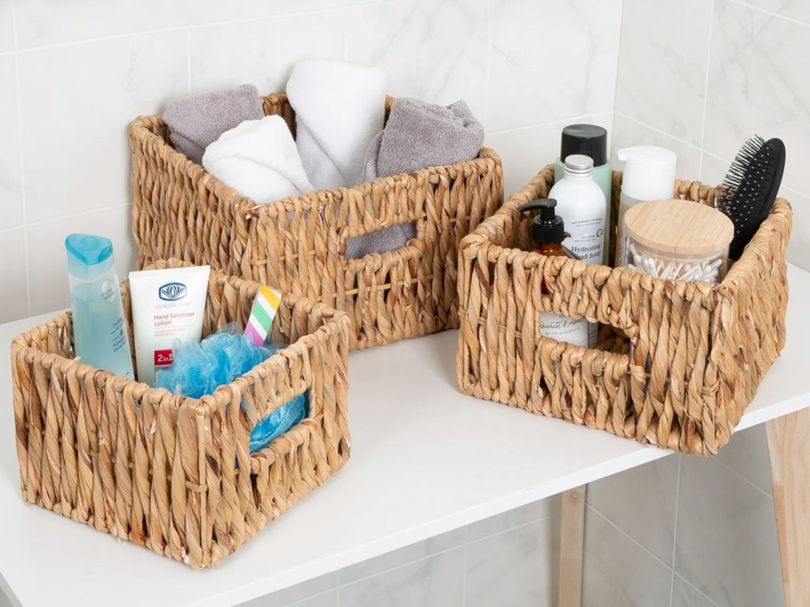 three wicker baskets full of bath products on shelf 