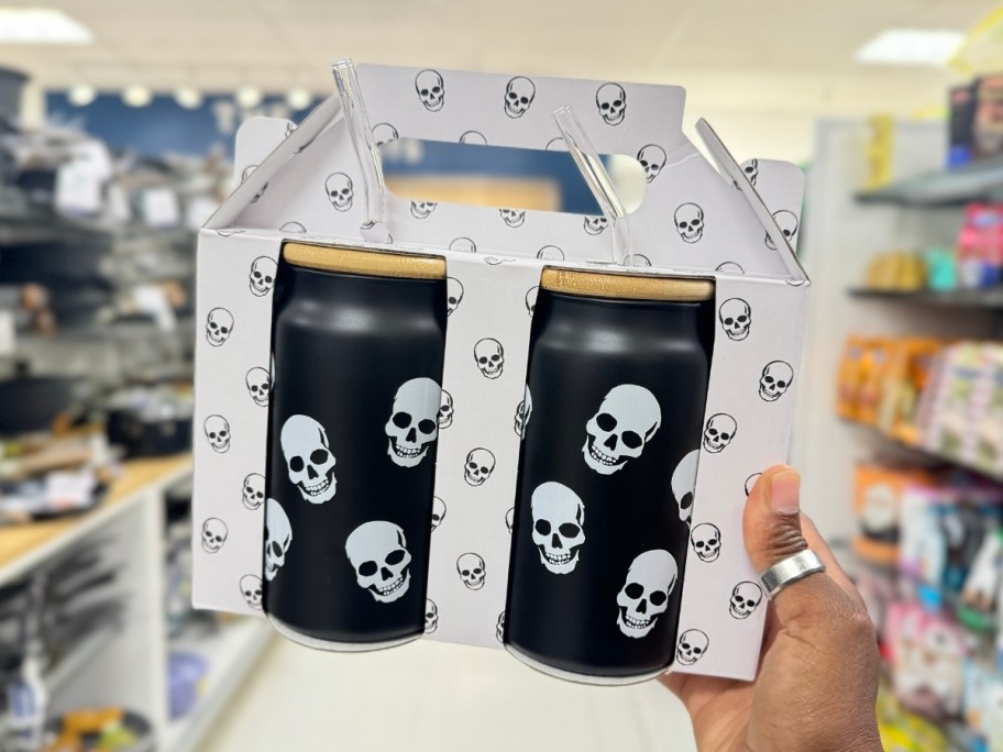 hand holding a box with 2 black Skeleton glass tumblers with bamboo lids