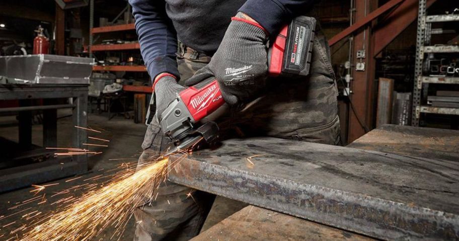 person using Milwaukee power tool on metal slab