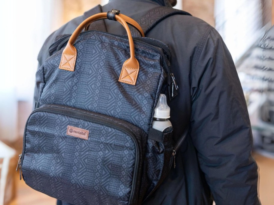 man wearing a blue print diaper bag backpack