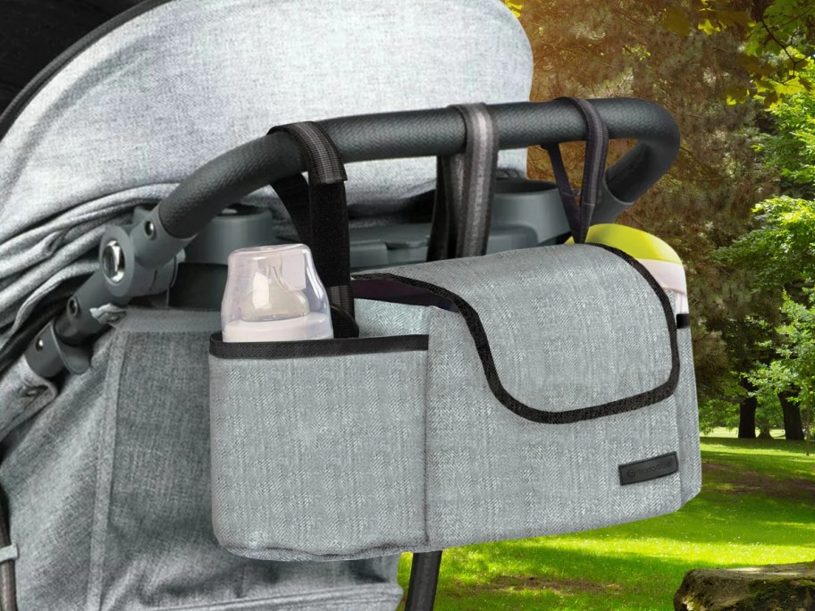 grey stroller with a grey and black stroller bag organizer attached to it