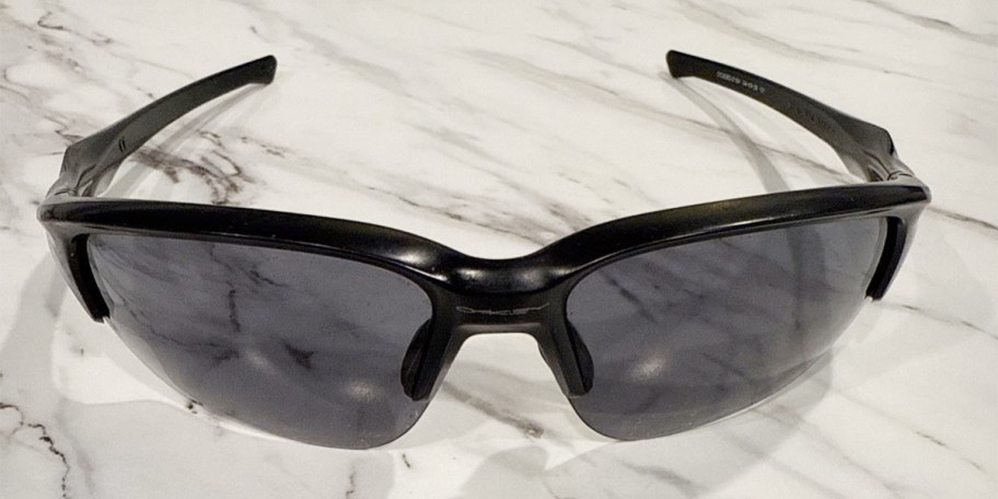 black and gray oakley mens sunglasses on counter