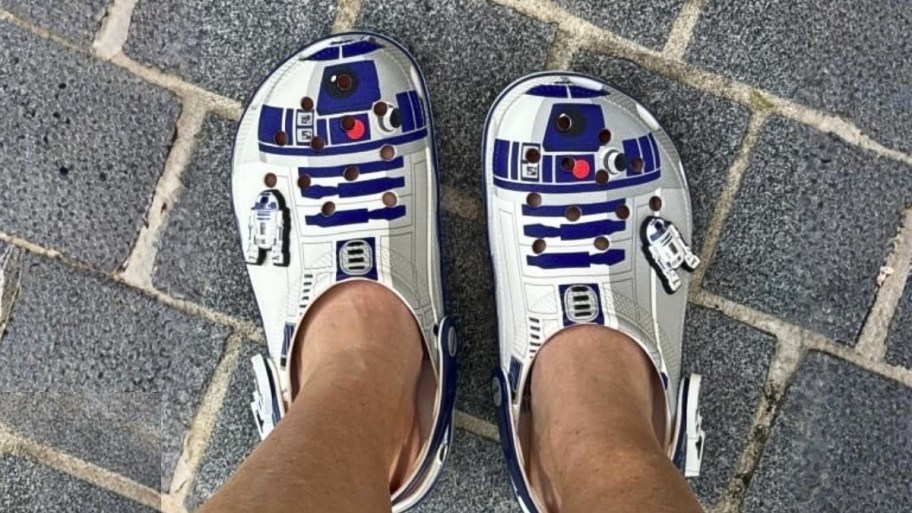 a persons feet wearing a pair of r2d2 crocs