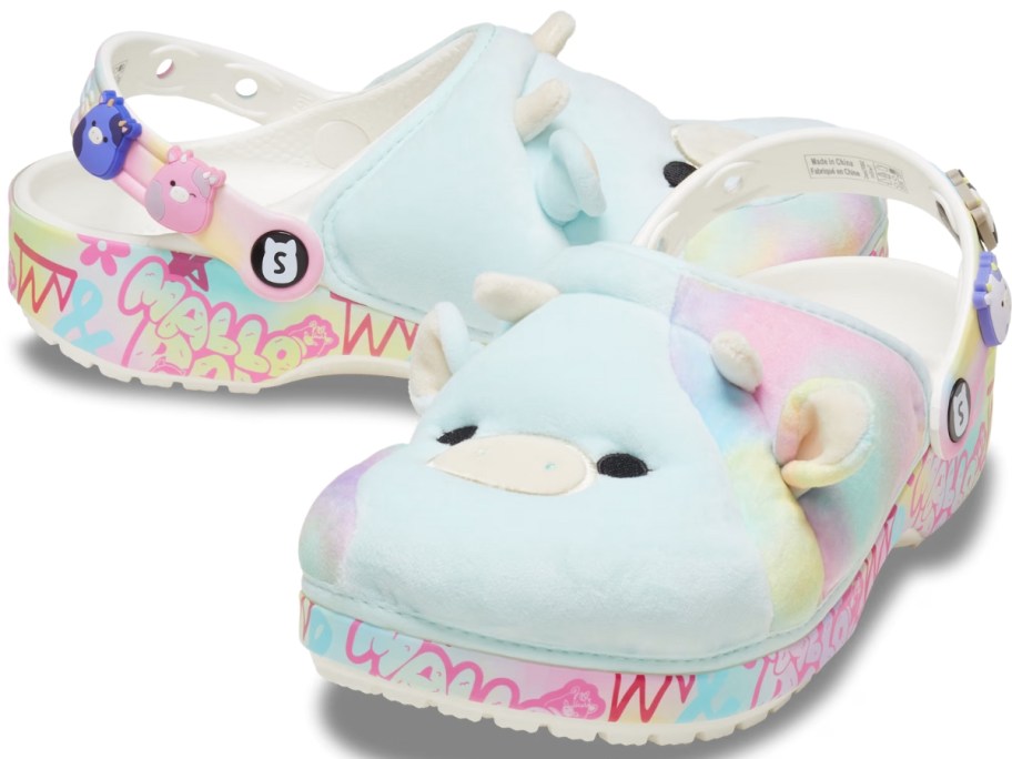 a light blue pair of Squishmallow Crocs with a pig figure, multi color sole and various Squishmallow characters on the heel straps