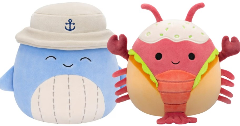 two large Squishmallow plsuh animals, one is a blue whale in a sailor hat and one is a lobster in a roll