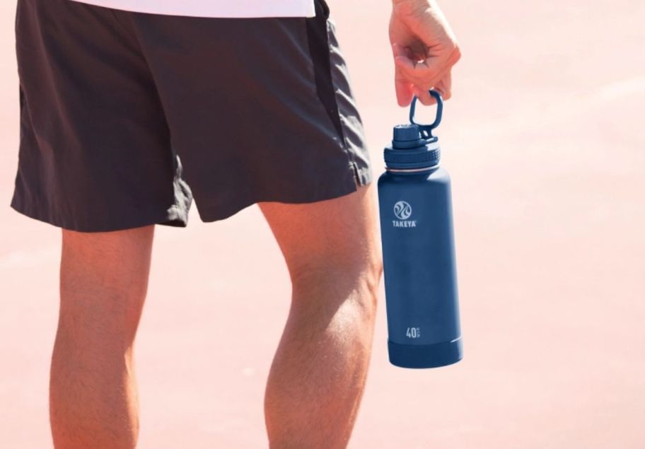 a mans hand carrying a 40oz takeya water bottle