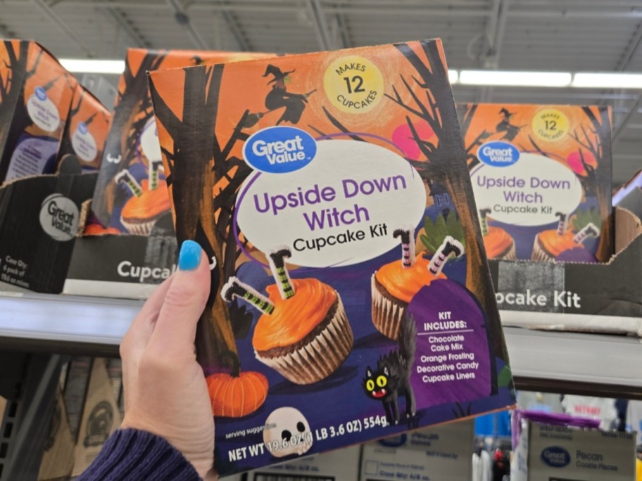 a womans hand holding a cupcake kit