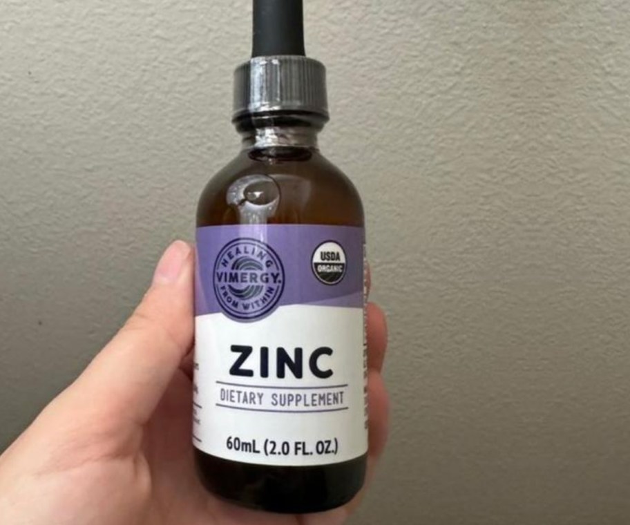 hand holding bottle of liquid zinc