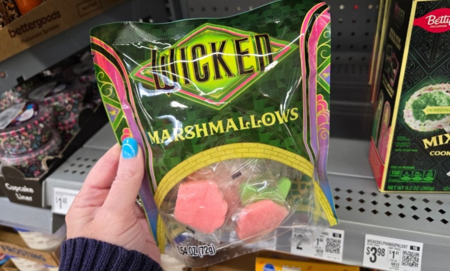 a womans hand holding a bag of wicked marshmallows