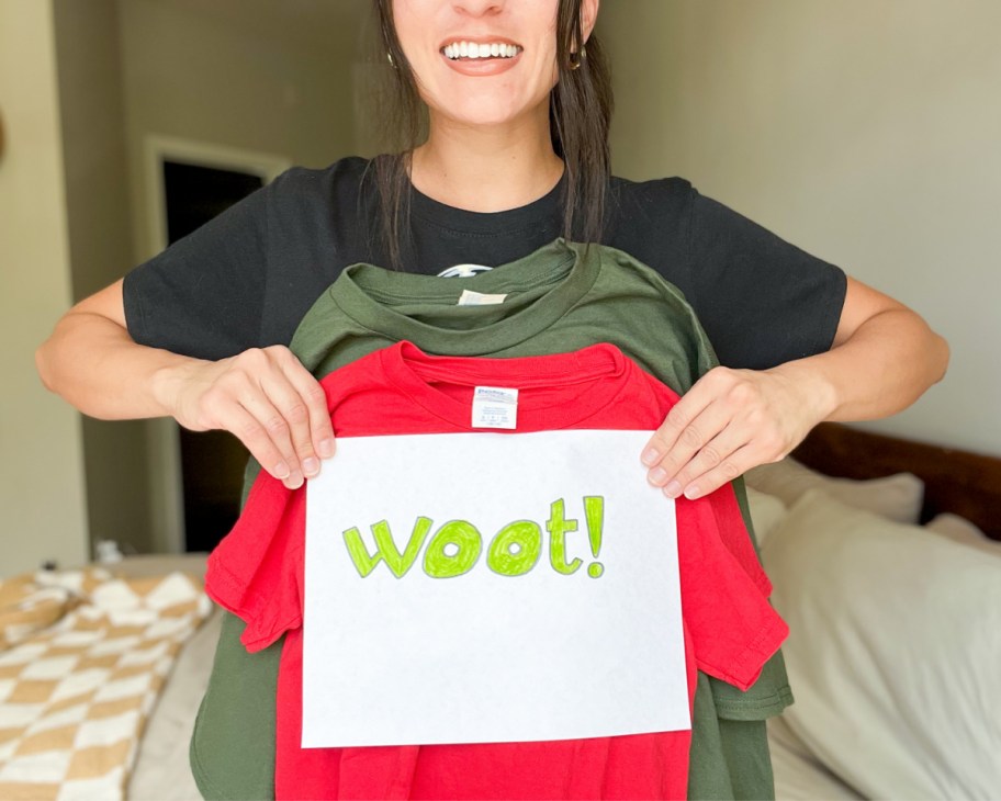 woman holding up woot sign and three t shirts