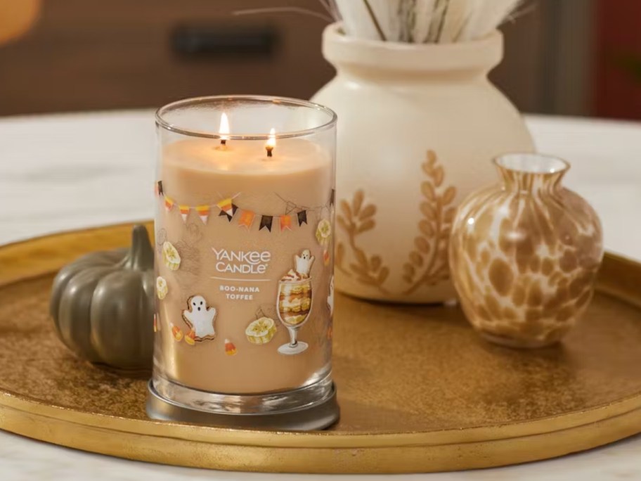 tan color Yankee Candle Jar Signature style candle in Halloween scent Boo-Nana Toffee on a tray with faux pumpkins and mini vases