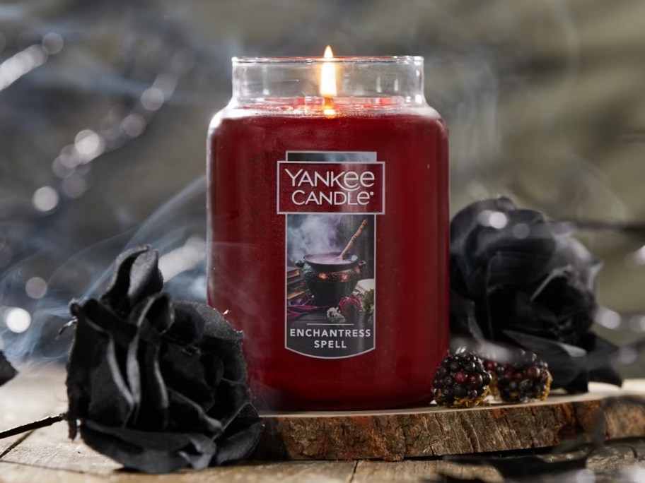 large red Yankee Jar candle lit, Halloween scent Enchanted Spell