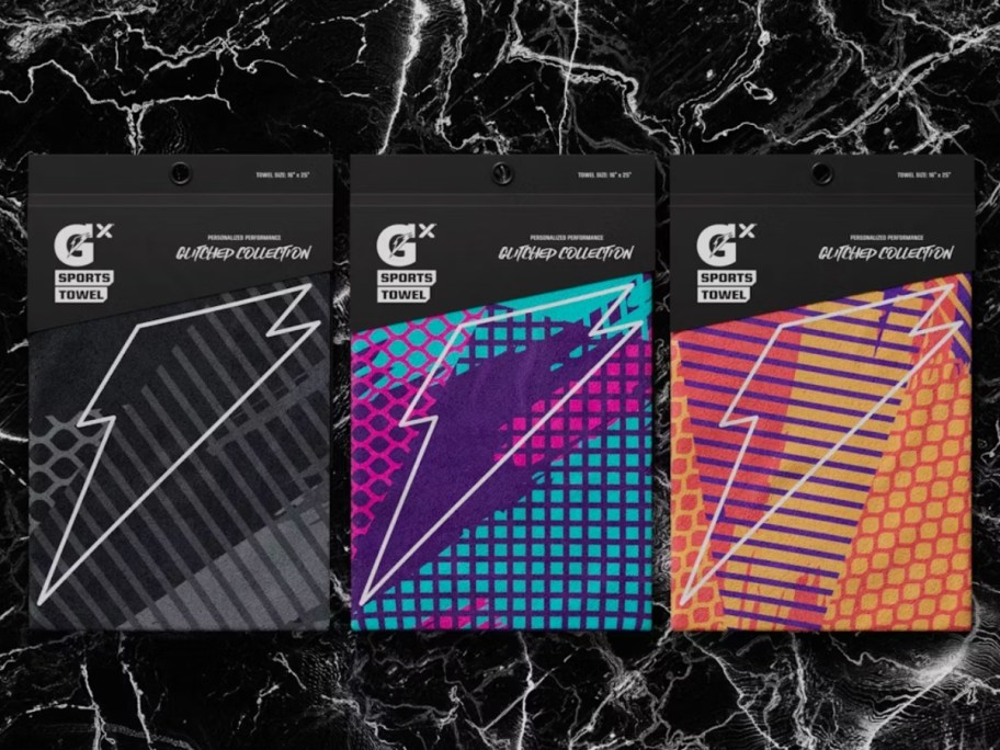 Three brightly colored Gatorade sports towels packed on a black and white counter.