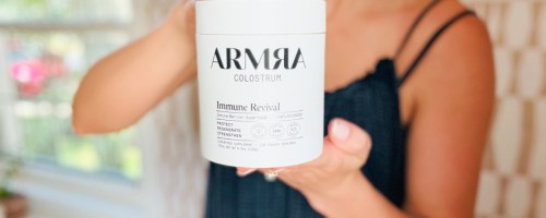 woman holding jar of armra colostrum