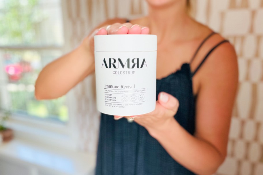 woman holding jar of armra colostrum