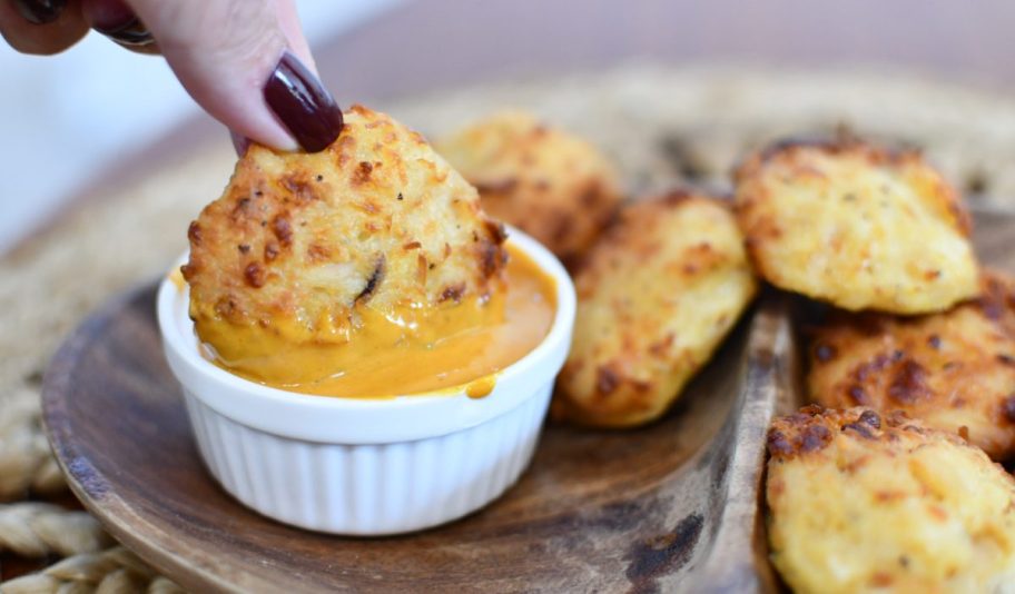 Canned chicken nuggets being dipped in sauce