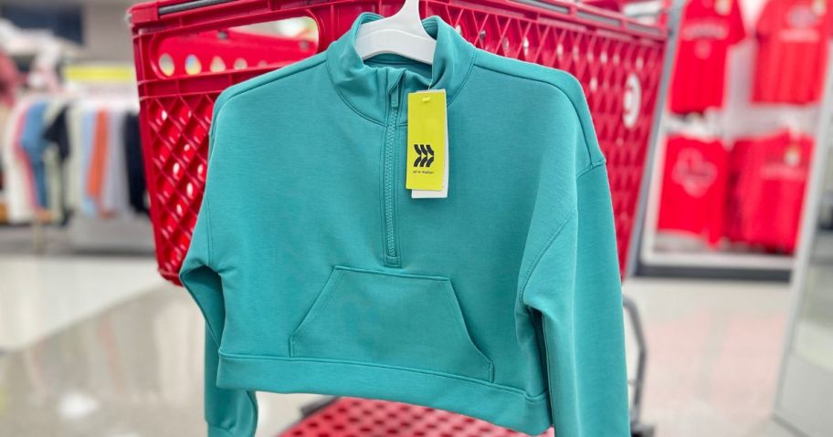 An All in Motion girl's lululemon lookalike sweatshirt hanging from a Target shopping cart