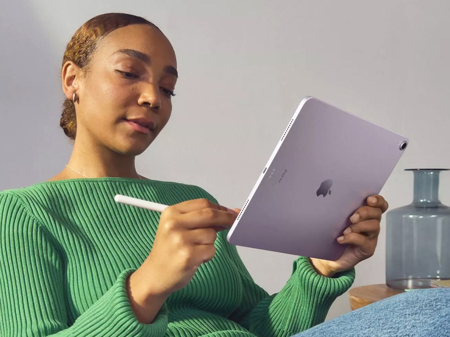 woman holding a purple ipad and apple pencil