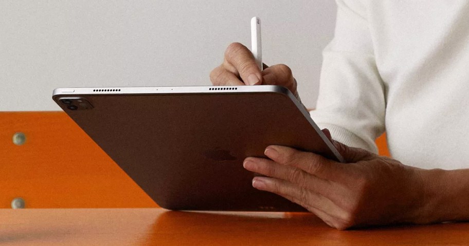 woman writing on an ipad with an apple pencil