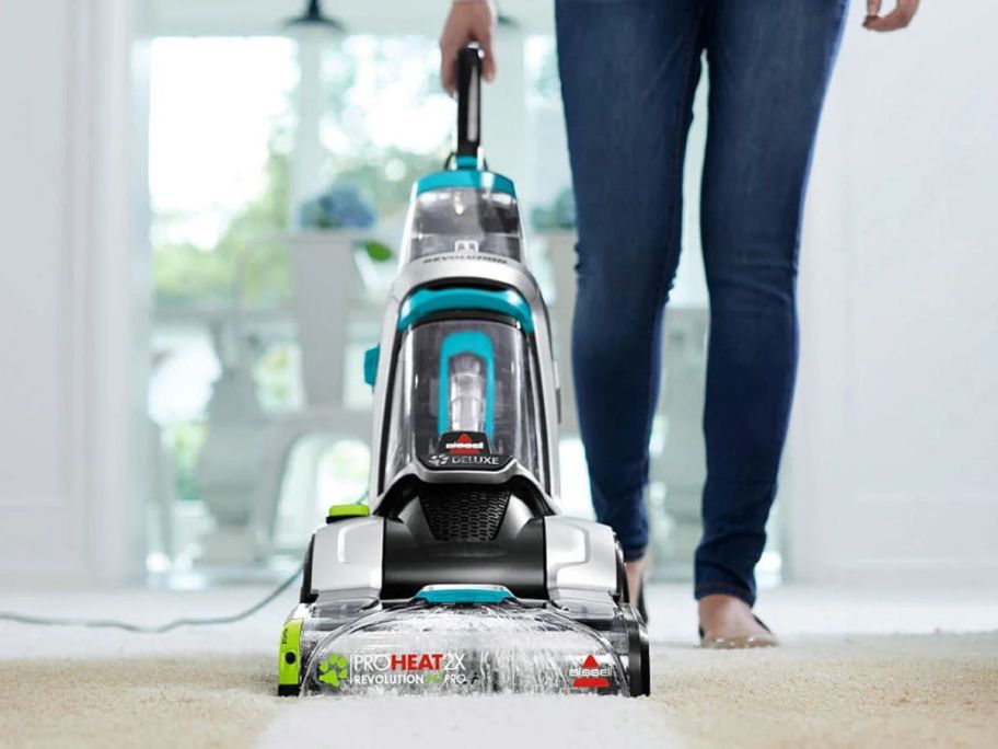 Woman using a Bissell ProHeat 2X Revolution Pet Pro Carpet Cleaner