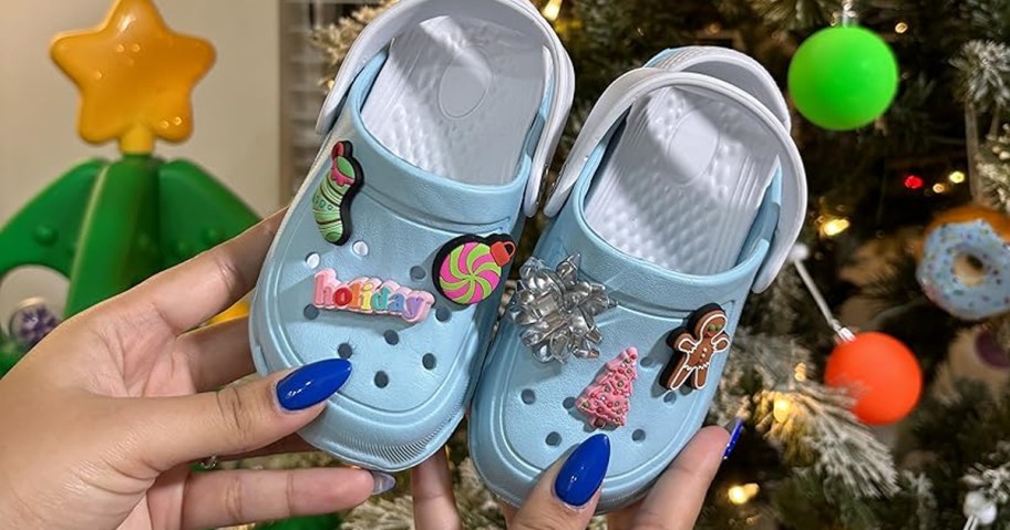 hands holding up toddler shoes covered in christmas jibbitz charms