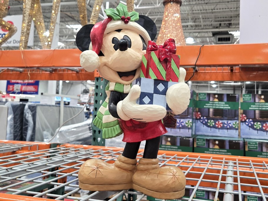 mickey statue holding a stack of presents