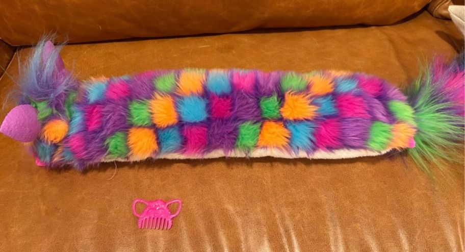 long tail furby displayed on the couch