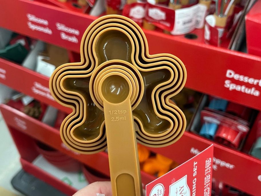 hand holding Holiday Time Gingerbread Man Measuring Cups Set