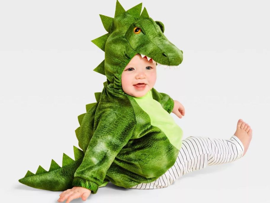 A toddler wearing a dinosaur costume
