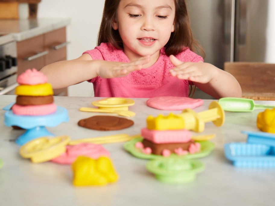 Kid playing with bakery set from green toys