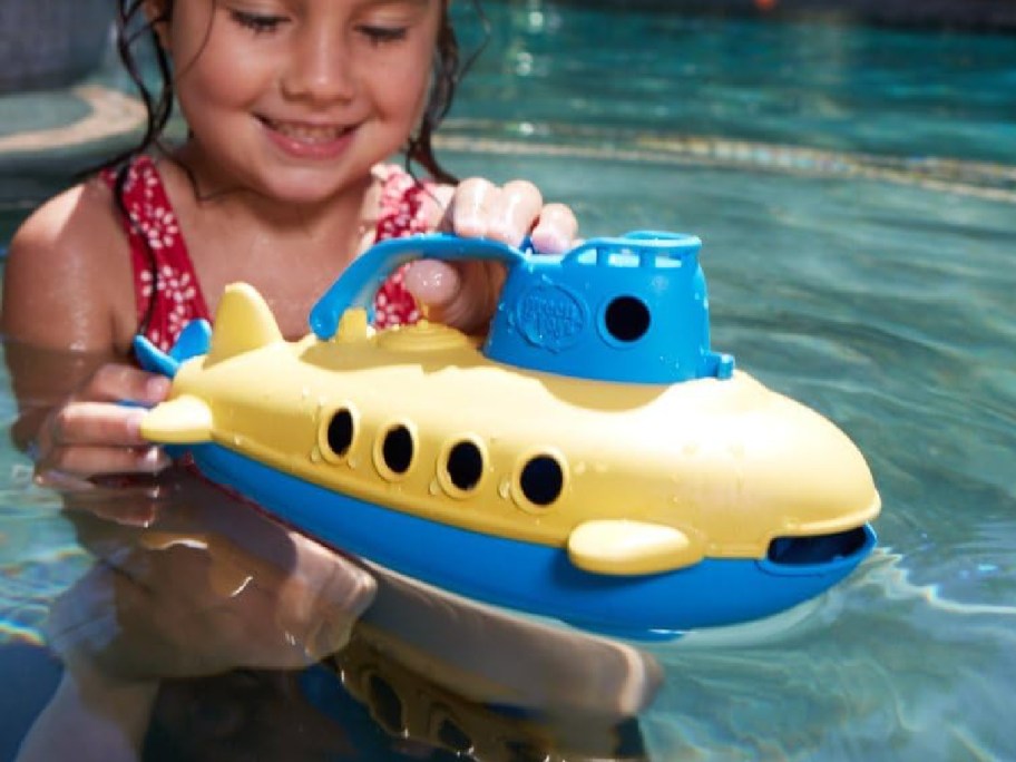 xKid playing with submarine green toy in the pool