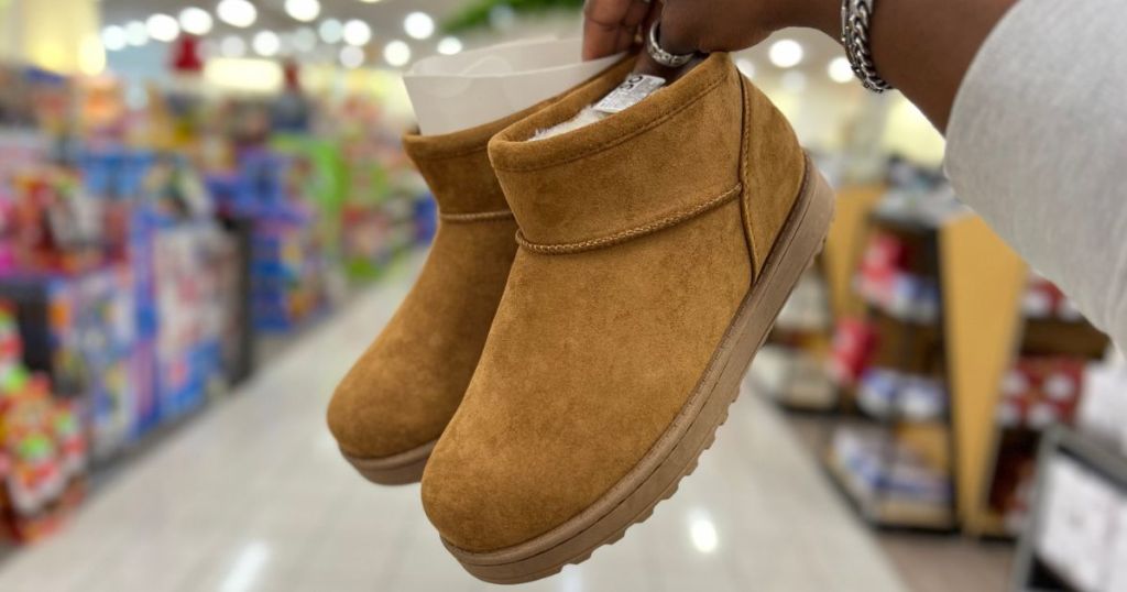 Hand holding a pair of Cozy Short SO Boots from Kohl's