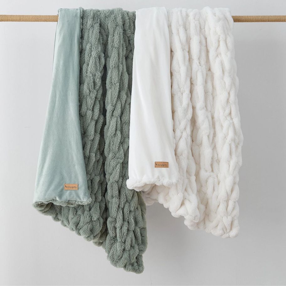 two comfy blankets draped over a dowel