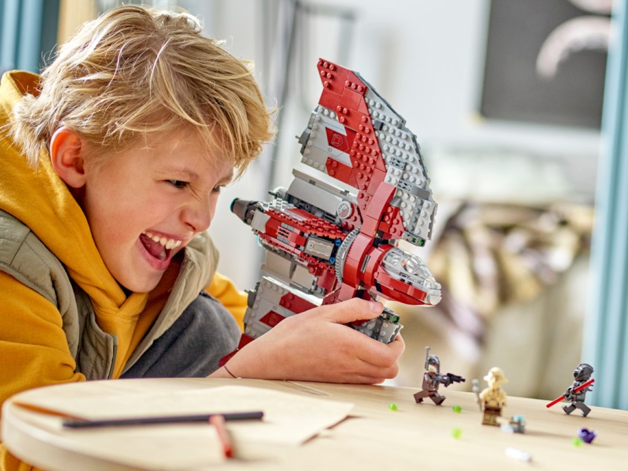 boy playing with lego star wars ship