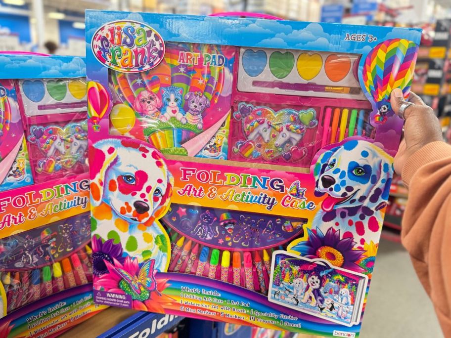 a womans hand holding a Lisa Frank art activity kit