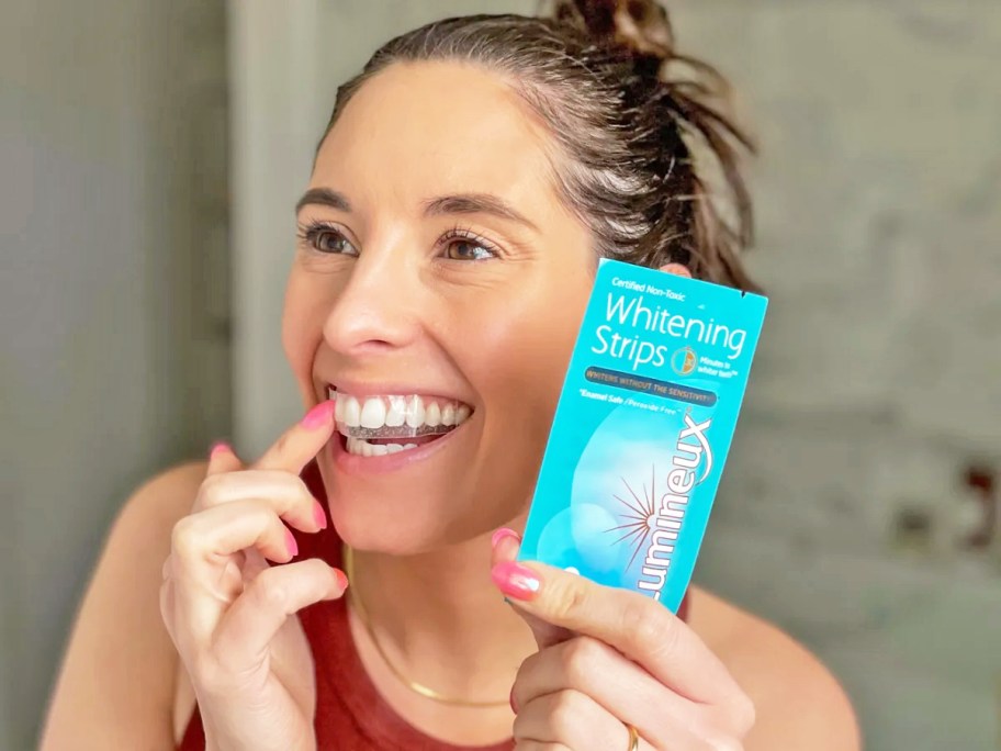 woman applying teeth whitening strips