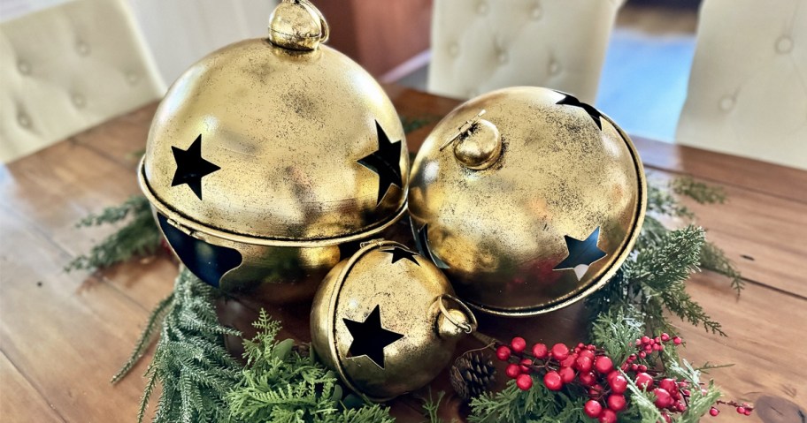 three large gold jingle bell balls as centerpiece on table