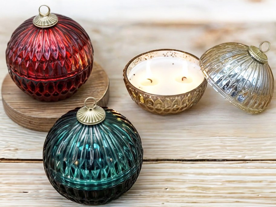 red, green, and gold ornament candles on wood table