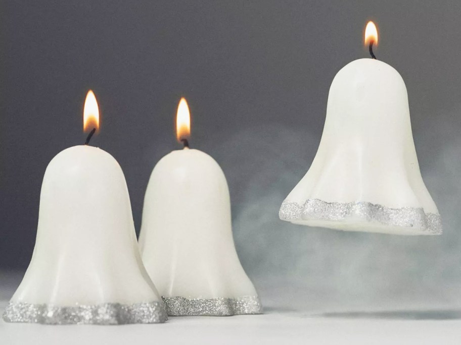 three white ghost candles with silver glitter at the bottoms