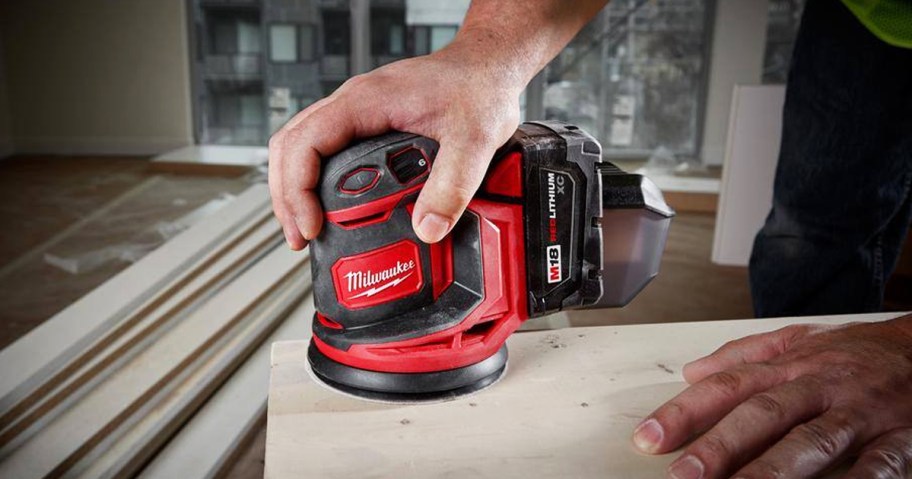 person using a Milwaukee 5" Random Orbit Sander