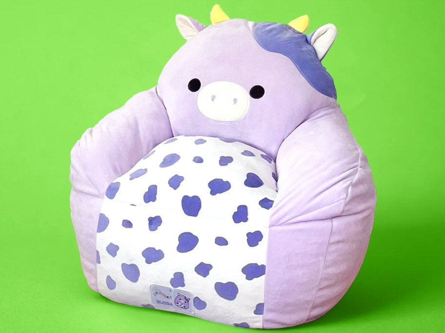 purple cow bean bag chair on green background