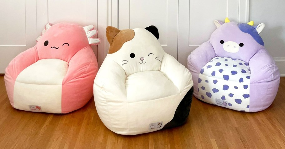 axolotl, cat, and cow Squishmallows bean bag chairs on floor