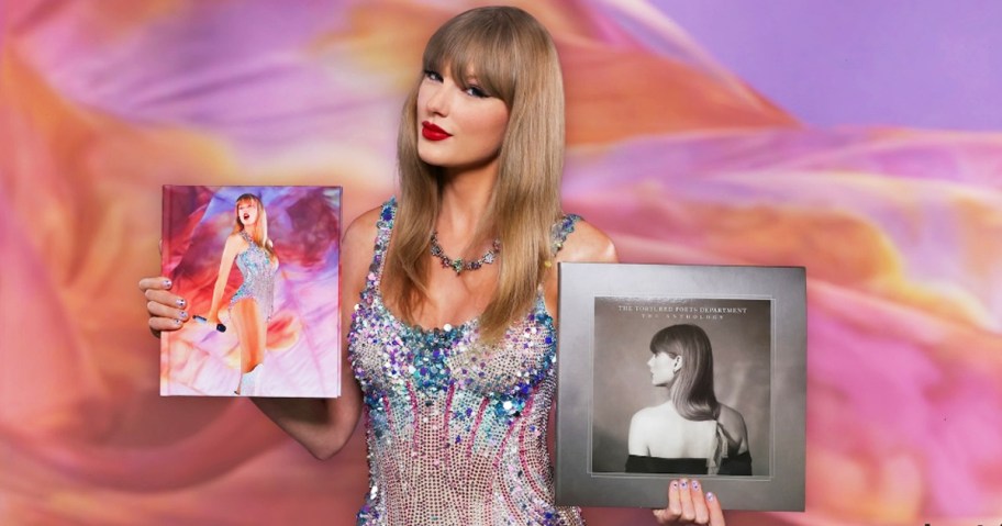 Taylor Swift holding Eras Tour book and The Tortured Poets Department: The Anthology album