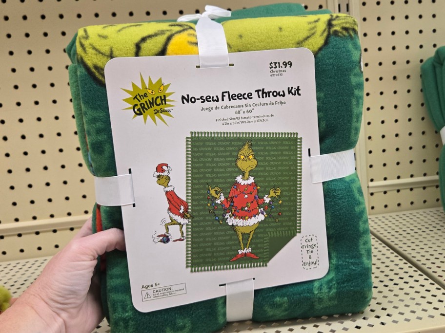 The Grinch No-Sew Fleece Throw Kit on a shelf at hobby lobby