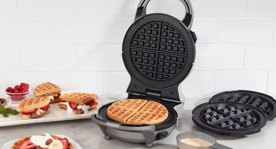 Waffle maker with replacable plates displayed with food on the table 