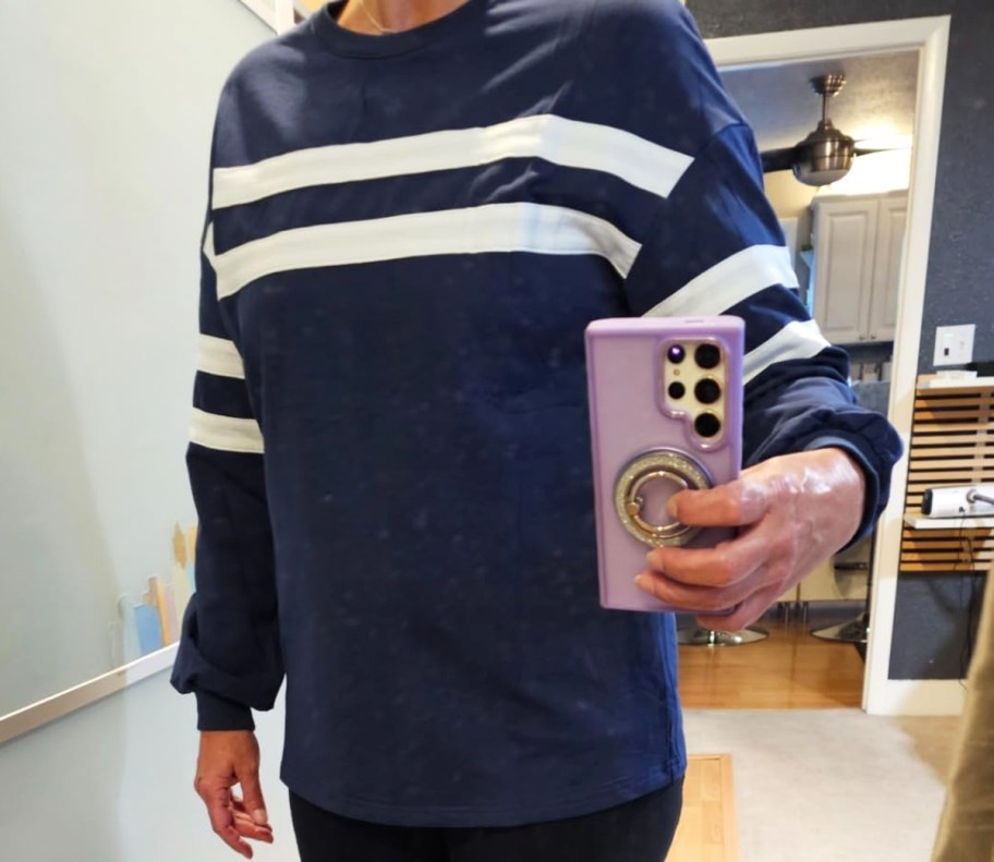 woman in navy blue sweatshirt taking photo in mirror